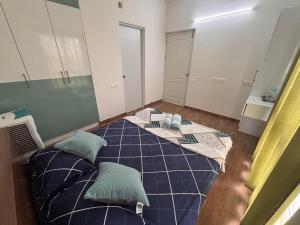 a bedroom with a blue bed with pillows on it at Podcast House in Chikmagalūr