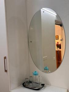 a bathroom with a mirror and a table with glasses at Podcast House in Chikmagalūr