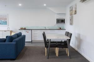a living room with a table and a blue couch at Bay View - Lounge Lovers in Lorne