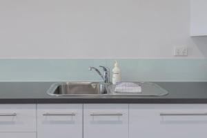 a kitchen sink with a bottle of soap on it at Bay View - Lounge Lovers in Lorne +8 photos