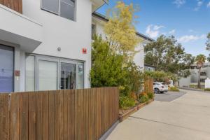 a house with a wooden fence next to a driveway at Bay View - Lounge Lovers in Lorne
