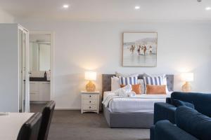 a bedroom with a bed and a blue couch at Bay View - Lounge Lovers in Lorne