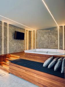 a large bathroom with a tub and a tv at BLUE HAT - Apart Hotel in Mogi das Cruzes