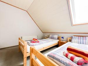 ein Dachgeschosszimmer mit zwei Betten und einem Fenster in der Unterkunft Medemblick in Ihlienworth