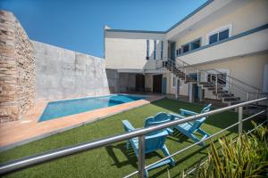 a house with a swimming pool and two blue chairs at Hotel Real Capital Tabasco in Villahermosa