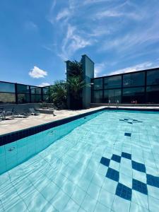 a swimming pool in front of a building at BLUE HAT - Apart Hotel in Mogi das Cruzes