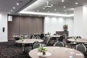 a conference room with tables and chairs and a wall at Mantra on Russell in Melbourne +59 photos