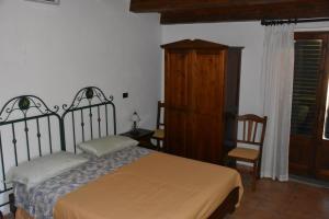 1 dormitorio con 1 cama y armario de madera en Azienda Agrituristica Biologica Il Querceto, en Santa Severina