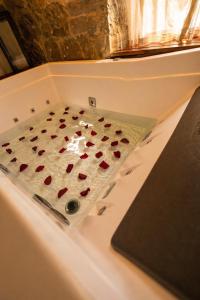 a bath tub with a shower with red hearts in it at Casa Vêneto -Vale dos Vinhedos in Bento Gonçalves