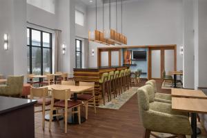 a restaurant with tables and chairs and a piano at Hampton Inn & Suites Baltimore North/Timonium, MD in Timonium