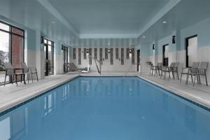 a swimming pool with chairs and tables in a building at Hampton Inn & Suites Baltimore North/Timonium, MD in Timonium