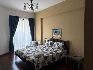 a bedroom with a bed and a large window at The Landmark By Katana Penang in Tanjong Tokong