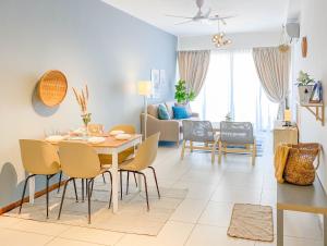 a dining room and living room with a table and chairs at The Landmark By Katana Penang in Tanjong Tokong