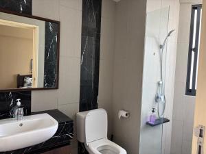a bathroom with a white toilet and a sink at The Landmark By Katana Penang in Tanjong Tokong