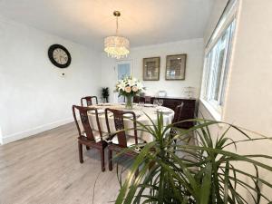 a dining room with a table and chairs and a clock at Vancouver Lucy House in Vancouver