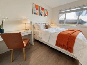 a bedroom with a bed and a desk and a chair at Vancouver Lucy House in Vancouver +9 photos