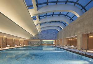a swimming pool in a hotel with a ceiling at Hilton Haikou in Haikou