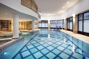 a large swimming pool with blue tiles in a building at DoubleTree by Hilton Glasgow Central in Glasgow