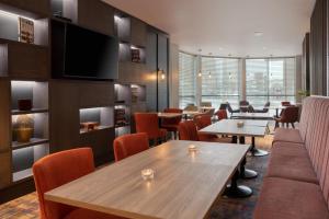 a restaurant with tables and chairs and a flat screen tv at DoubleTree by Hilton Glasgow Central in Glasgow