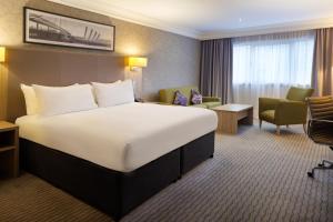 a hotel room with a large bed and a chair at DoubleTree by Hilton Glasgow Central in Glasgow +89 photos