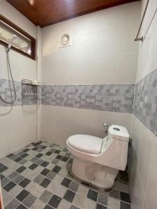 a bathroom with a toilet and a tiled floor at Gun Eng Resort กันต์เองรีสอร์ท in Ban Nong Nam Sang
