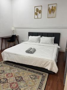a bedroom with a bed with two pillows and a rug at Dynz Cottage in Banting