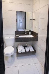 a bathroom with a sink and a toilet at Suíte Executiva - Climatizada in Erval dʼOeste +4 photos