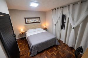 a bedroom with a white bed and two lamps at Suíte Executiva - Climatizada in Erval dʼOeste