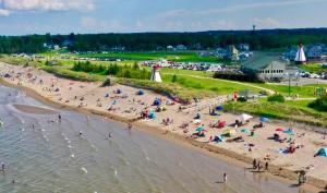 a group of people on a beach near the water at Waterfront Cottage ''The Dream'' with Hot Tub, near Parlee Beach in Shediac +56 photos