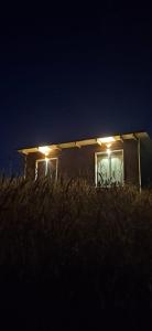 a house with lights on the side of it at night at Luz de mareas in Ancud +1 photo