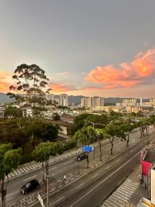 a city street with cars on a road with trees at BLUE HAT - Apart Hotel in Mogi das Cruzes