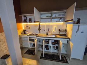 a kitchen with a sink and a white refrigerator at Studio Completo Próx aeroporto Guarulhos in Guarulhos