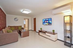 a living room with a couch and a tv on a wall at Kaskade House in Yerevan