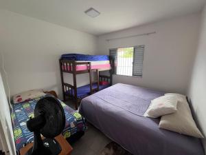 a bedroom with two twin beds and a fan at A Casa da Sogra in Bertioga
