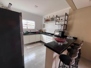a kitchen with a counter and some chairs in it at A Casa da Sogra in Bertioga