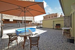 a patio with a table and an umbrella at Kaskade House in Yerevan