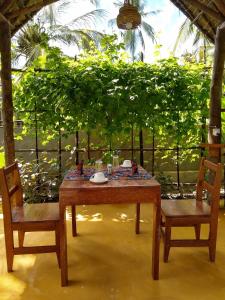 a wooden table and two chairs and a table and chairs at LalaMafia Bungalow in Utende