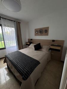 a bedroom with a bed with a black and white blanket at La Delfina in Chacras de Coria +25 photos