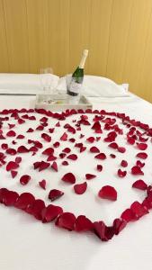 a bunch of hearts on a bed with a bottle of wine at Conchas Lofty in Governador Celso Ramos