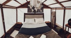 a bedroom with a bed in a tent at Chalés & glamping primitivo Búzios in Búzios