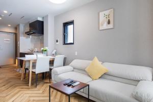 a living room with a couch and a table at Hopetree NambaImamiya in Osaka +71 photos