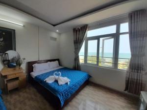 a bedroom with a bed with a bow on it at Khách sạn Đông Tây Quy Nhơn in Quy Nhon +49 photos