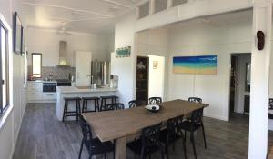 a kitchen and dining room with a wooden table and chairs at Sunrise on the Esplanade in Yeppoon