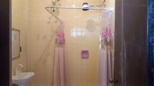 a bathroom with a shower curtain and a sink at Pousada Vila Bela in Poços de Caldas