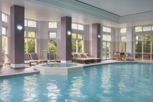 a large swimming pool with chairs and a table at DoubleTree by Hilton Dartford Bridge in Dartford