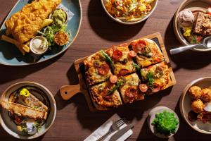 a table topped with a pizza and plates of food at DoubleTree by Hilton Dartford Bridge in Dartford