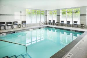 a swimming pool with chairs in a building at Hampton Inn & Suites Bridgewater, NJ in Bridgewater