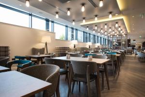 a restaurant with tables and chairs and windows at Hampton By Hilton Edinburgh West End in Edinburgh