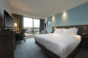 a hotel room with a bed and a desk and a television at Hampton By Hilton Edinburgh West End in Edinburgh