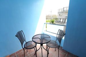 three chairs and a table on a balcony at My Starry Bed and Breakfast in Taitung City